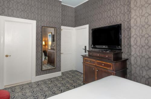 a bedroom with a television and a dresser with a mirror at Historic Inns of Annapolis in Annapolis