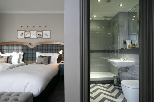 a bedroom with a bed and a shower and a sink at Dog and Fox in London