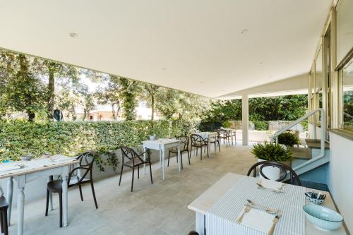 a restaurant with tables and chairs and a wall of ivy at Park Hotel Giusy in Lido di Camaiore
