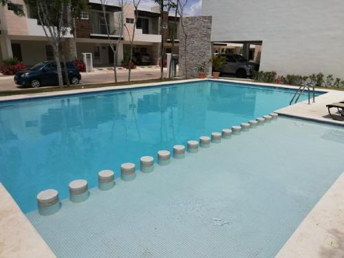 ein großer blauer Pool in einem Gebäude in der Unterkunft Cozy Family Vacation Home near the beach! in Playa del Carmen