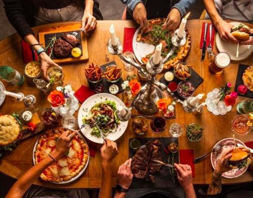 a group of people sitting around a table with food at DU GLACIER Boutique & Traditions Hotel in Fiesch