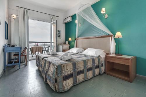 een slaapkamer met een bed met een blauwe muur bij Eros Beach Hotel in Benitses