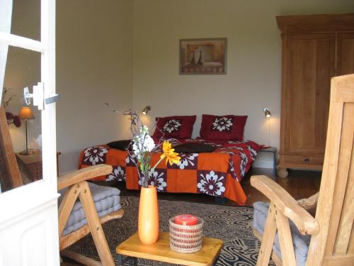 - un salon avec un lit et un vase de fleurs dans l'établissement Bordo Basso, à Laugnac