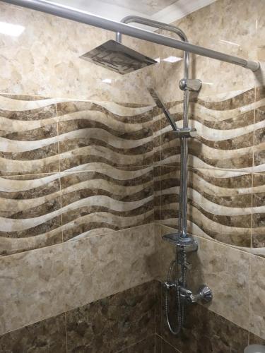 una doccia in un bagno con un motivo a onde sulla parete di DILIJAN Apartment a Dilijan