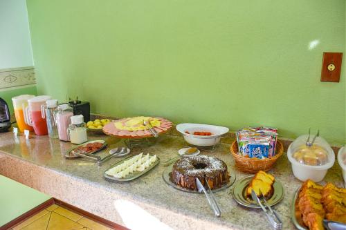 a counter topped with plates of food and desserts at Hotel Vivenda das Cachoeiras in Brotas