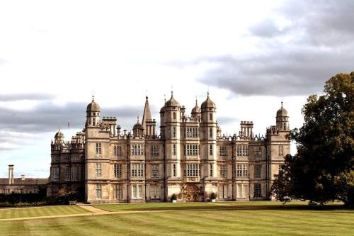 a large castle with a grass field in front of it at Stamford Guest House in Stamford