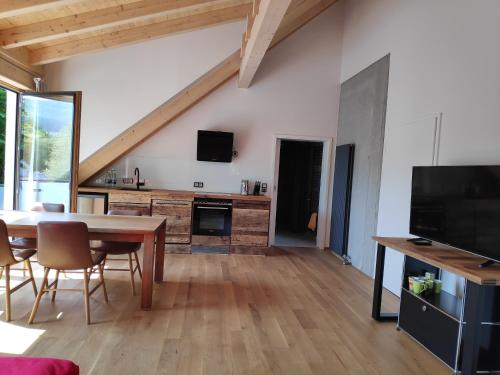 a living room with a dining room table and a tv at Ferienwohnungen und Zimmer in Reutlingen-Gönningen in Reutlingen