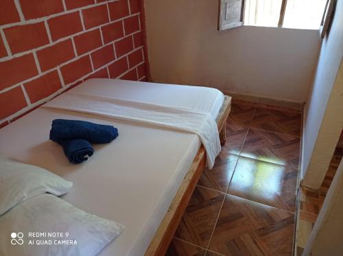 a small room with two beds and a brick wall at HOSTAL BELLEZA TROPICAL in Moñitos