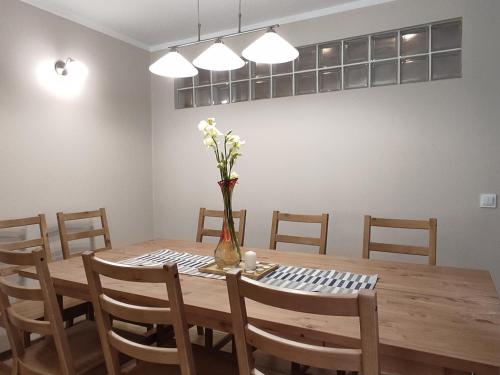 a dining room table with a vase of flowers on it at Siedlisko Błotnia in Mierzeszyn