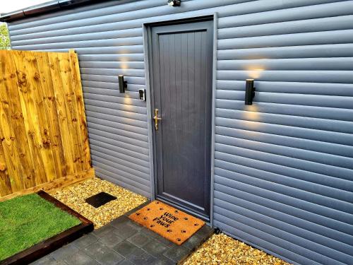 a door on the side of a metal building at Yaseva Lodge, Stylish Country Retreat for 2, Hot Tub, Exceptional Views! in Carr