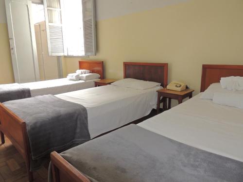 a room with two beds and a telephone in it at Hotel Esplanada Belo Horizonte - Proximo a Estacao de Trem in Belo Horizonte
