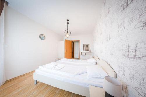 sypialnia z dużym białym łóżkiem ze ścianą w obiekcie Privilege Fort Beach - Sea Viev Premium Apartments w Elenite