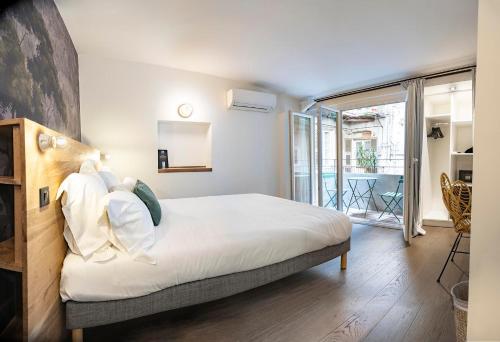 a bedroom with a bed and a large window at Monsieur Miot Concept Hotel - Bastia centre in Bastia