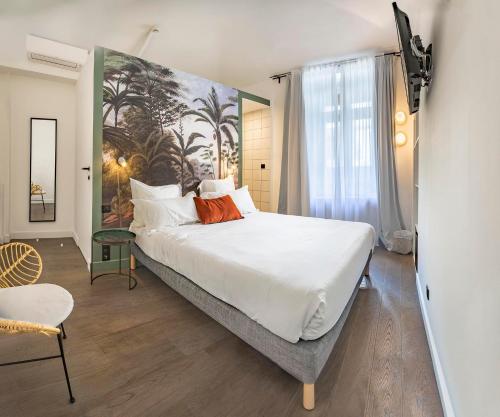 a bedroom with a large bed with a painting on the wall at Monsieur Miot Concept Hotel - Bastia centre in Bastia