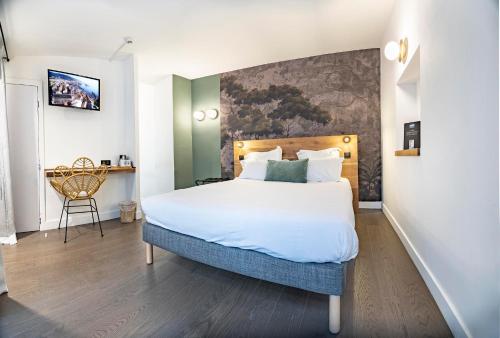a bedroom with a large bed and a desk at Monsieur Miot Concept Hotel - Bastia centre in Bastia