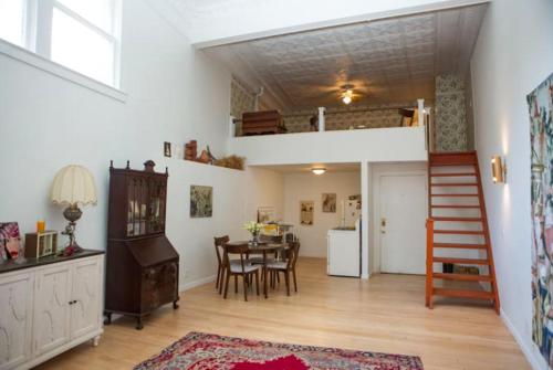 a living room with a table and a loft bed at Object Hotel - 1A Loft in Bisbee
