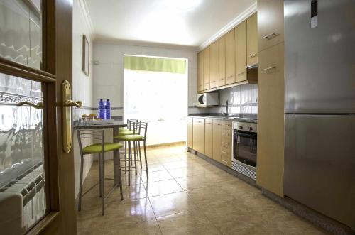 a kitchen with a table and chairs and a refrigerator at Apartamento en Raxó in Pontevedra