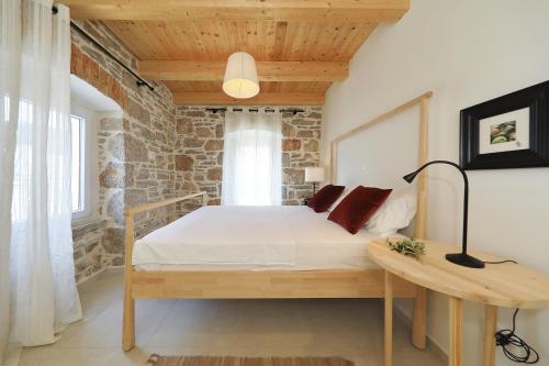 a bedroom with a bed and a table with a lamp at Villa Mira with a heated pool and a sea view in Božava