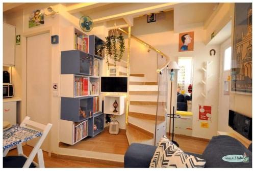a room with a staircase with bookshelves and a living room at Casinha da Ti Babel in Faro