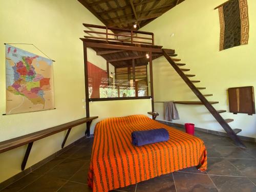 a bedroom with a bed with an orange blanket at Barranquero Hotel in El Zaino