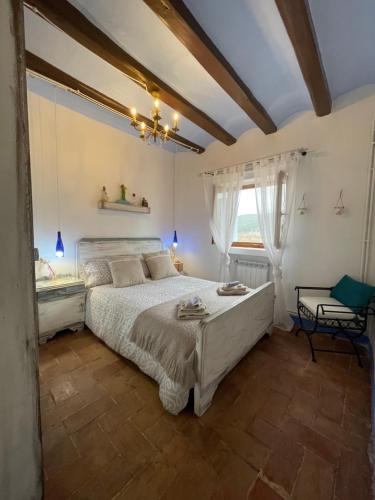 1 dormitorio con cama blanca y ventana en Ca L'Esquelleta casa rural, en Vilaverd