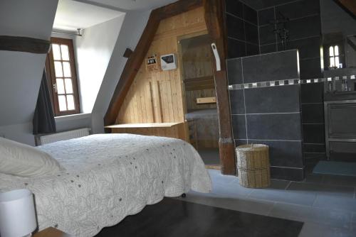 une chambre avec un grand lit et une douche dans l'établissement Gite du Pont Saint-Céneri-Le-Gérei dans les Alpes Mancelles, à Saint-Céneri-le-Gérei