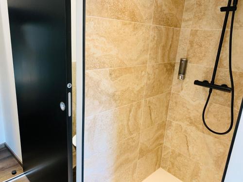 a bathroom with a shower with a black door at Chambre Le Merindol in Aix-en-Provence