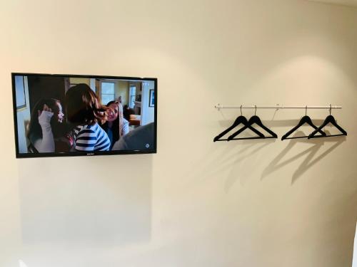 a mirror hanging on a wall with hangers at Chambre Le Merindol in Aix-en-Provence