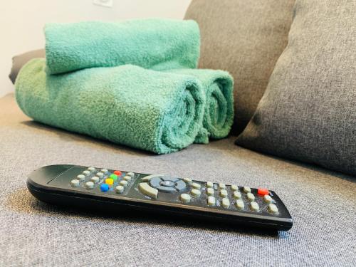 a remote control sitting on a couch with a towel at Chambre Le Merindol in Aix-en-Provence