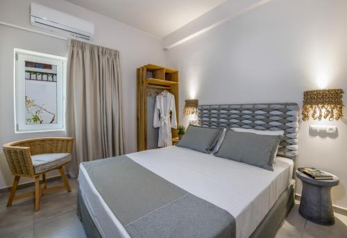 a bedroom with a large bed and a chair at Eleana Nature & Art in Khóra Sfakíon