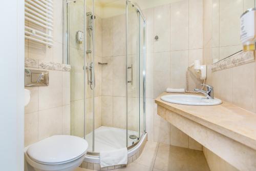 a bathroom with a shower and a toilet and a sink at Aparthotel Old Town in Kraków