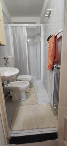 a bathroom with two toilets and a shower and a sink at La casetta del Marinaio in Tellaro