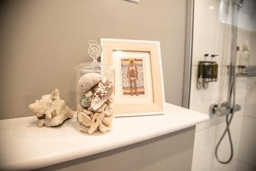 a white shelf with a picture and a frame on it at The Garden Apartment in Deal