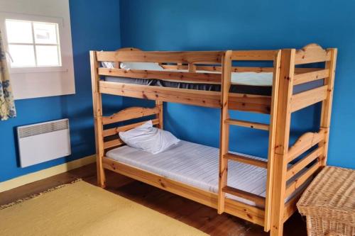 two bunk beds in a room with a blue wall at La Jaunette, Charmant Fenil avec piscine in Labarthe-Rivière