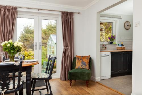 a kitchen and dining room with a table and a window at Grey Goose Cottage in Lochs
