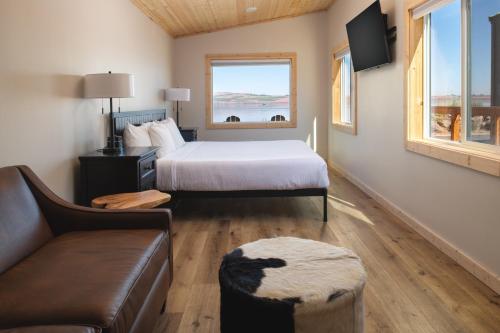 1 dormitorio con cama, sofá y ventana en River Lodge and Cabins, en Boardman