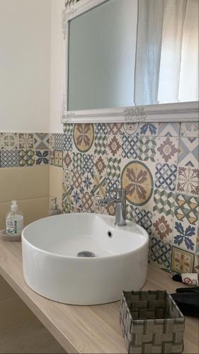 a white sink in a bathroom with tiles at BnB Le Janas in Càbras