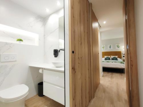 OVIEDO CENTRO SANTA CLARA PISO DE LUJO في أوفِييذو: حمام مع مرحاض وسرير في غرفة