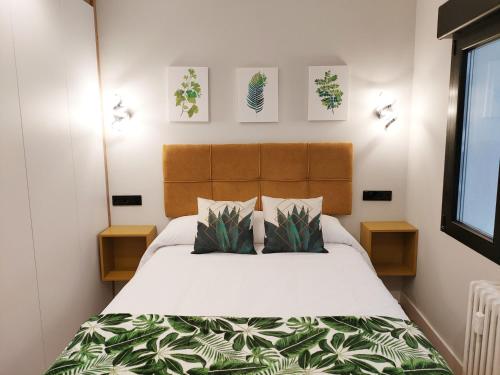 ein Schlafzimmer mit einem Bett und zwei Nachttischen in der Unterkunft OVIEDO CENTRO SANTA CLARA PISO DE LUJO in Oviedo