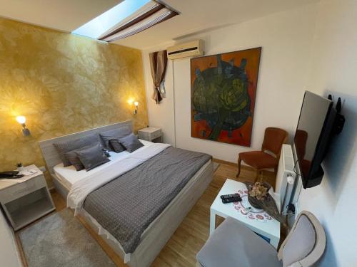 um quarto com uma cama, uma TV e uma mesa em TEPIĆ Garni Hotel em Temerin
