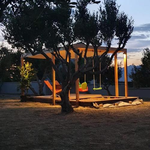 a playground with a tree in a park at Apartman Petar in Ražanac