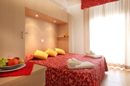 فندق ميموسا في بيلاريا-إيجيا مارينا: غرفة بها سرير مع وعاء من الفواكه عليها