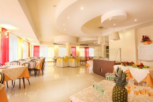 sala bankietowa ze stołami i krzesłami oraz ananasem na podłodze w obiekcie Hotel Mimosa w mieście Bellaria-Igea Marina