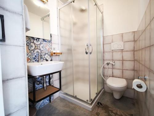 a bathroom with a shower and a toilet and a sink at Villa Torre Dell'Altomare con piscina, blocco n2 - Apulia Home in Alliste