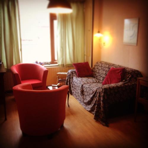 een woonkamer met een bank en 2 stoelen bij Huisje Stockholm op Terschelling in West-Terschelling
