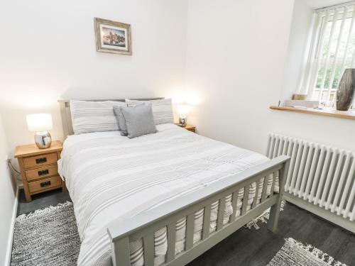 a bedroom with a large bed with white sheets at 2 Mountain View in Llangefni