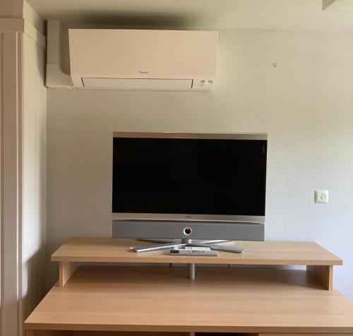 a flat screen tv sitting on top of a wooden table at B&B Bloemenweelde in Kortrijk