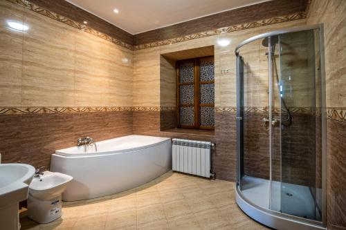 uma casa de banho com uma banheira, um chuveiro e um lavatório. em Rynek 7 - Apartamenty em Bielsko-Biala