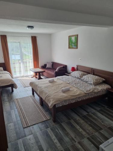 a bedroom with a large bed and a couch at Apartmani JEZERO in Žabljak