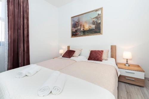 ein Schlafzimmer mit 2 Betten und einem Bild an der Wand in der Unterkunft Apartment St. Antonio in Rovinj